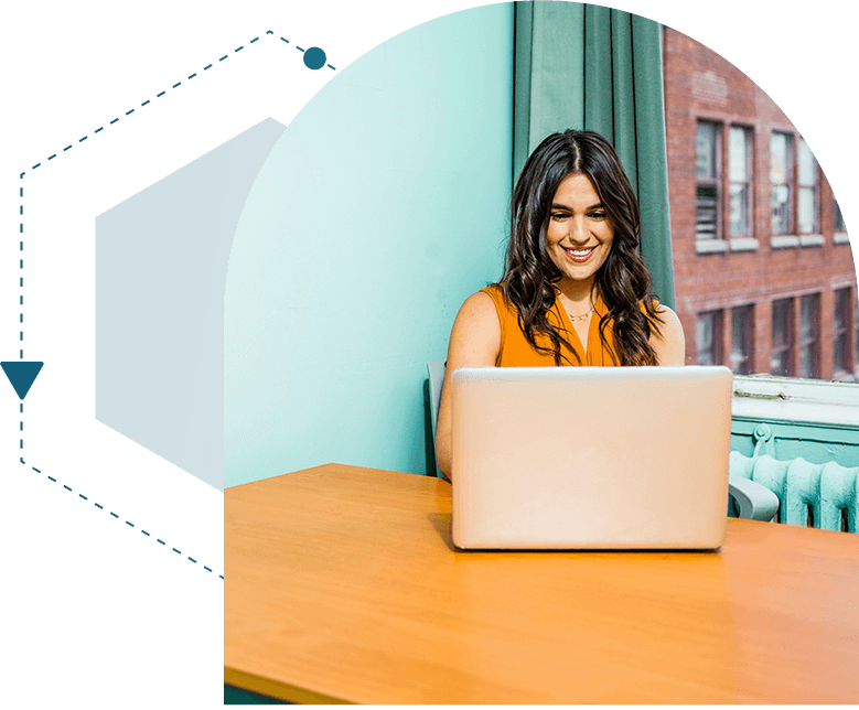 A woman sitting at a table with a laptop.